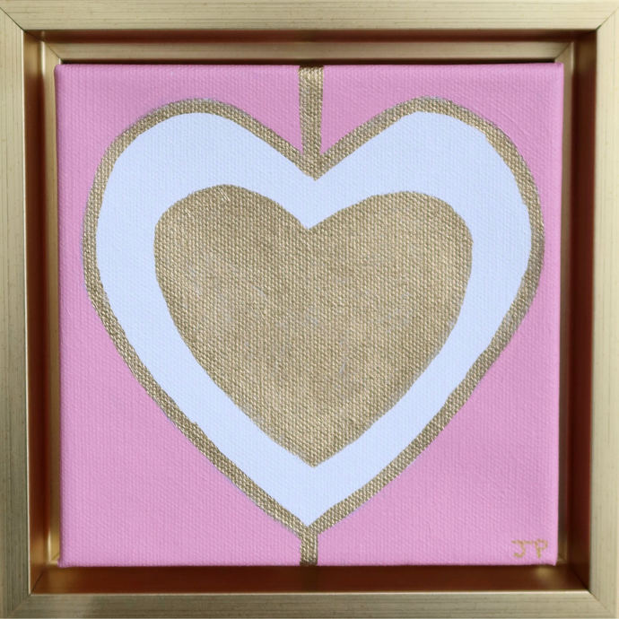 Heart Art painting on Canvas. This original heart artwork has a gold heart inside a white heart outlined in gold on a pink background. It is a square painting and comes in a gold float frame. It is initialed  by the artist on the front.