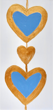 Load image into Gallery viewer, Two blue hearts outlined in gold with a gold heart between them. This original work of art is a shel sitter and has gold sides. The hearts are on a white background. Heart art painting. This is a small vertical original blue and gold heart painting.