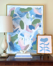 Load image into Gallery viewer, Blue flower painting on a pink background. in a gold bamboo frame. Styled with a large abstract painting.