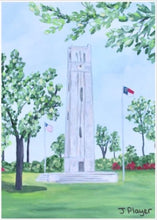 Load image into Gallery viewer, NC State Bell Tower Art on a Free Standing Acrylic Block. This is a vertical landscape artwork of NCSU Memorial Belltower reproduced on an acrylic block. The belltower is in grassy field with blooming trees and shubbery. It is a small 5 x 7 inch block perfect to give for NC State graduation gift or alumni gift. Wolfpack art gift.
