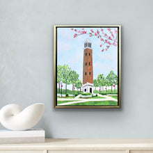 Load image into Gallery viewer, Officially licensed Crimson Tide artwork of Denny Chimes surrounded by blooming dogwoods and green trees painted on gallery wrapped canvas and framed in gold. Graduation gift idea for Bama students.