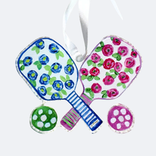 Load image into Gallery viewer, This pickleball ornament has a colorful floral design with shades of blue, green, pink and white. It is made of shatterproof acrylic and has a cut out shape. It is lightweight and has a white satin ribbon.