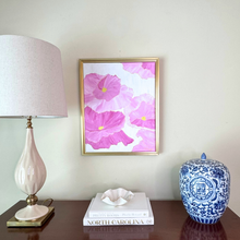 Load image into Gallery viewer, An original work of art by Jeanne Player with bold oversized Pink poppies with yellow centers on a white background. This 16 x 20 vertical artwork is styled with traditional decor a white lamp and a chinoiserie ginger jar.