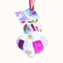 Load image into Gallery viewer, Pink Confetti ornament is a colorful original artwork on a ceramic ornament. This abstract ornament has shades of pink and gold on a white background and looks like confetti. The ornament has a gold top and pink ribbon. It has a pink ribbon.