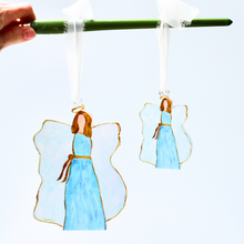 Load image into Gallery viewer, Faith-inspired acrylic angel ornament designed for Christmas trees and meaningful holiday decorating.
Blue and white angel ornament with blonde hair and glossy dimensional finish for festive decor.
Religious Christmas tree ornament featuring original angel artwork by Jeanne Player.