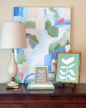 Load image into Gallery viewer, Tradiitional home decor with a Currey and co cream lamp, 2 framed botanical paintings, and a colorful abstract painting on a wall.