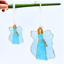 Load image into Gallery viewer, Blue and White angel ornaments outlined in gold with a gold sash and gold halo.  These whimsical angels are available in two sizes. They are made of acrylic and have a white ribbon.
