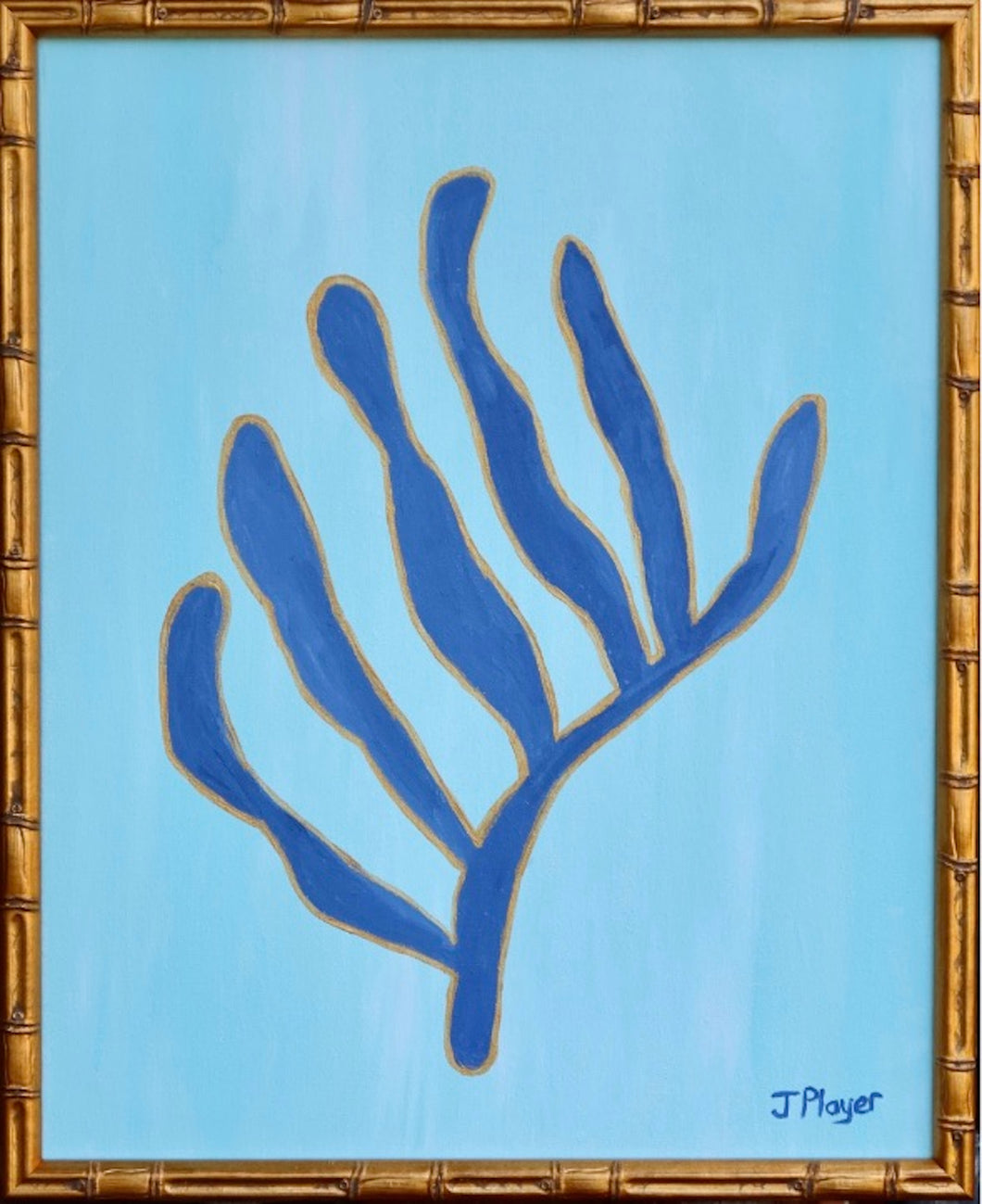 This is a bold and preppy seaweed art design on canvas. This painting has shades of light blue in the background and dark blue seaweed shape outlined in gold. It is in a gold bamboo frame. It is inspired by Matisse's cut out series.