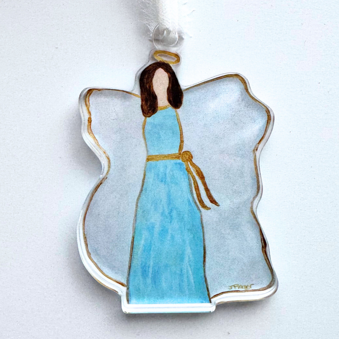 An angel ornament that is made of acrylic. It has an angel wearing blue with a gold sash, brown hair, gold halo, white wings outlined in gold.  It has a three dimensional look and the image is visible from both sides.