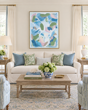 Load image into Gallery viewer, Celebrations original abstract painting by Jeanne Player displayed above a cream sofa in an elegant Hamptons-style living room, featuring a gold float frame and soft blue, green, pink, and white brushstrokes.
