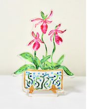 Load image into Gallery viewer, The Ladyslipper Freestanding Acrylic Block is a colorful artwork in acrylic. This cutout acrylic block art has three pink orchid blooms, green leaves in a beautiful cachepot with a fun design in blue and green on a white background with gold feet and outlined in gold.
