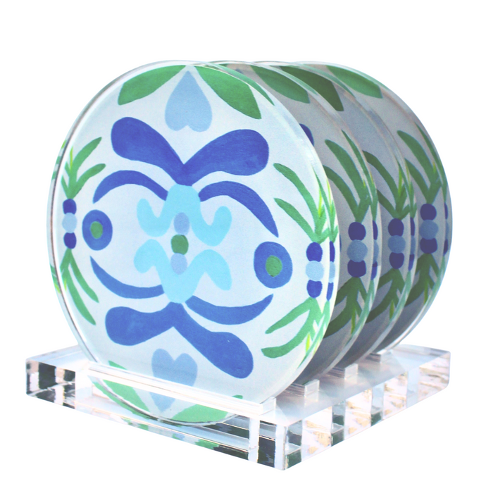 Colorful Coaster acrylic coaster set with stand. The Nantucket Coasters come in a set of four. They are round and made of acrylic. They have an acrylic stand that is square. They have a coastal inspired pattern with shades of blue and green on a white background. You can choose the option of a display stand.