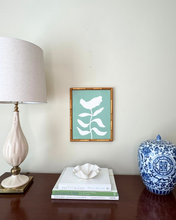 Load image into Gallery viewer, Decorative items on a table including a currey and company lamp, books, a chinoiserie vase, and an original floral green and white painting.  Grandmillennai style.
