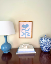 Load image into Gallery viewer, soft and feminine blue and pink floral art in a gold bamboo frame. styled with a chinoiserie ginger jar and a blue ballard designs lamp. Perfect for coastal and grandmillennial interiors.
