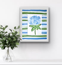 Load image into Gallery viewer, Framed artwork with blue and green abstract design on a white wall, next to a vase with green leaves.
