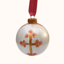 Load image into Gallery viewer, Original hand painted christian cross ornament that is shades of pink, white and gold. This is a round ornament that comes with a gold ribbon. It has an abstract design with a gold cross with pink dots on the ends.
