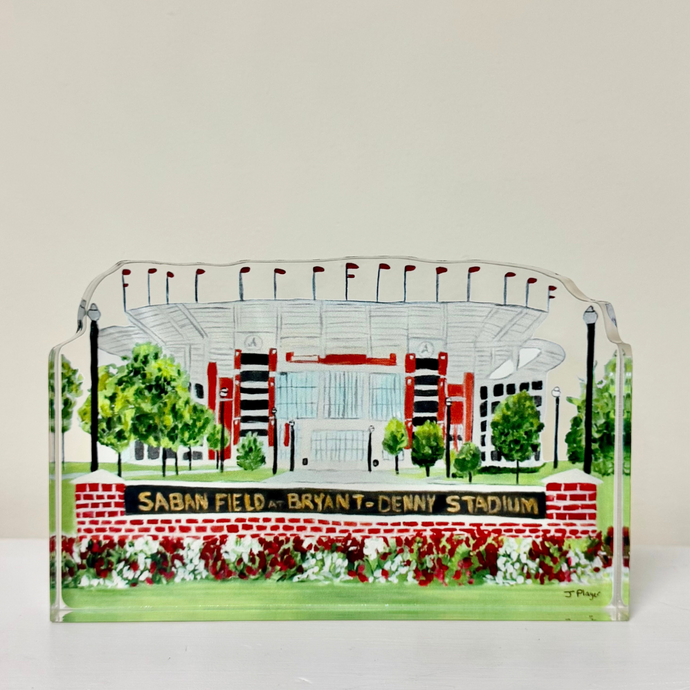 Saban Field at Bryant-Denny Stadium acrylic art block by Jeanne Player. Freestanding shelf sitter cutout featuring original Alabama football artwork in red, green, white, black, and gray. Measures 4.5 x 7 inches, with a 3D effect. Perfect for University of Alabama Crimson Tide fans, students, and alumni.
