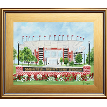 Load image into Gallery viewer, Roll Tide! Original artwork of Saban Field at Byant - Denny Stadium at The University of Alabama. This painting shows the iconic sign in front of the stadium with red and white flowers. The black lampost and red flags flying over the stadium. This painting is a horiontal landscape and comes in a gold plein air frame.
