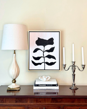Load image into Gallery viewer, Modern luxe interior with a lamp, framed black and white floral artwork, books, and candles on a wooden surface.
