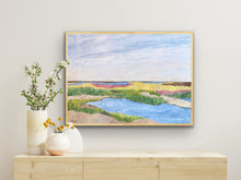 Load image into Gallery viewer, Colorful Low Country marsh landscape print displayed in a coastal bedroom with neutral décor and natural wood accents.
