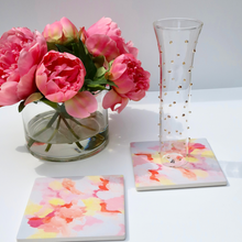 Load image into Gallery viewer, Pretty in Pink ceramic coaster displayed on a coffee table, adding colorful grandmillennial style and protecting furniture from drink rings.
