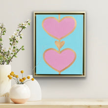 Load image into Gallery viewer, Original pink heart painting on aqua canvas in a gold float frame by Jeanne Player Fine Art.
Contemporary heart artwork featuring two pink hearts outlined in gold on a blue background.
