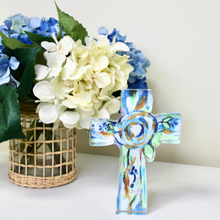 Load image into Gallery viewer, Faith-inspired acrylic block art with a colorful abstract floral cross design displayed on a clear acrylic shelf sitter for tabletop decor.
