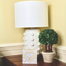 Load image into Gallery viewer, Heartstrings XII acrylic block artwork with layered white and gold hearts displayed on a clear freestanding acrylic shelf sitter, creating modern glam tabletop decor.
