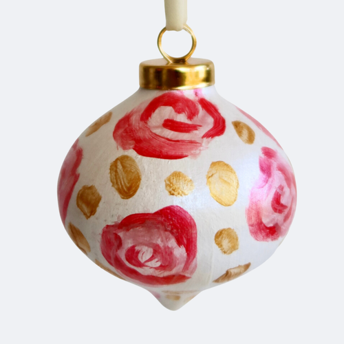 Hand painted abstract pink floral Christmas Tree ornament with pink flowers, gold dots on a white background. A white ribbons for hanging. This ornament has a gold top and is signed by the artist  Jeanne Player on the bottom.