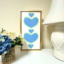 Load image into Gallery viewer, Preppy heart wall art with layered blue and green hearts painted on a modern acrylic canvas. These hearts have a coastal vibe.
