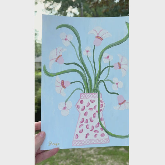 A whimsical floral painting on paper with shades of pink, coral, green, white, animal print on a light blue background.