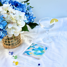 Load image into Gallery viewer, Sea glass inspired ceramic coasters featuring original abstract coastal artwork by Jeanne Player in blue, green, white, yellow, and coral tones, perfect beach house decor and ocean lover gift.
