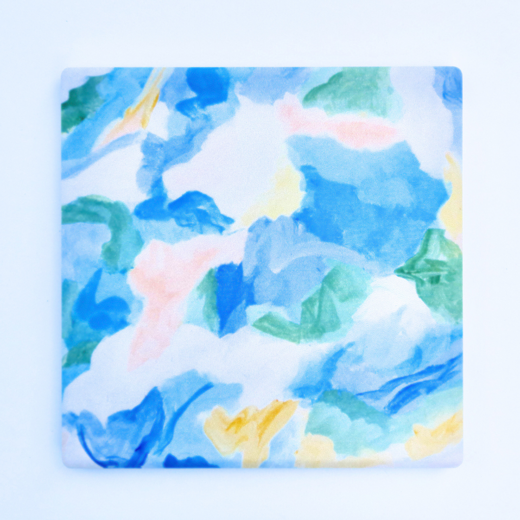 The Seaglass Coaster has shades of blue, green, yellow, white and coral.  It is an abstract design. The coaster is square.
