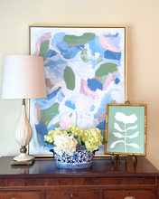 Load image into Gallery viewer, Transitional styled table with green and blue abstract art, lamp, and floral arrangement on a wooden surface with a green and white floral painting.
